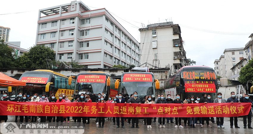 覃子苡 摄活动现场,多辆悬挂着"返粤复工'点对点'免费专车"字样横幅的