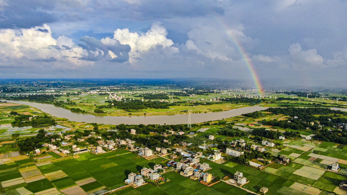 8月11日,一道彩虹高挂在合浦县南流江两岸上空,和蓝天,白云,田园,村庄