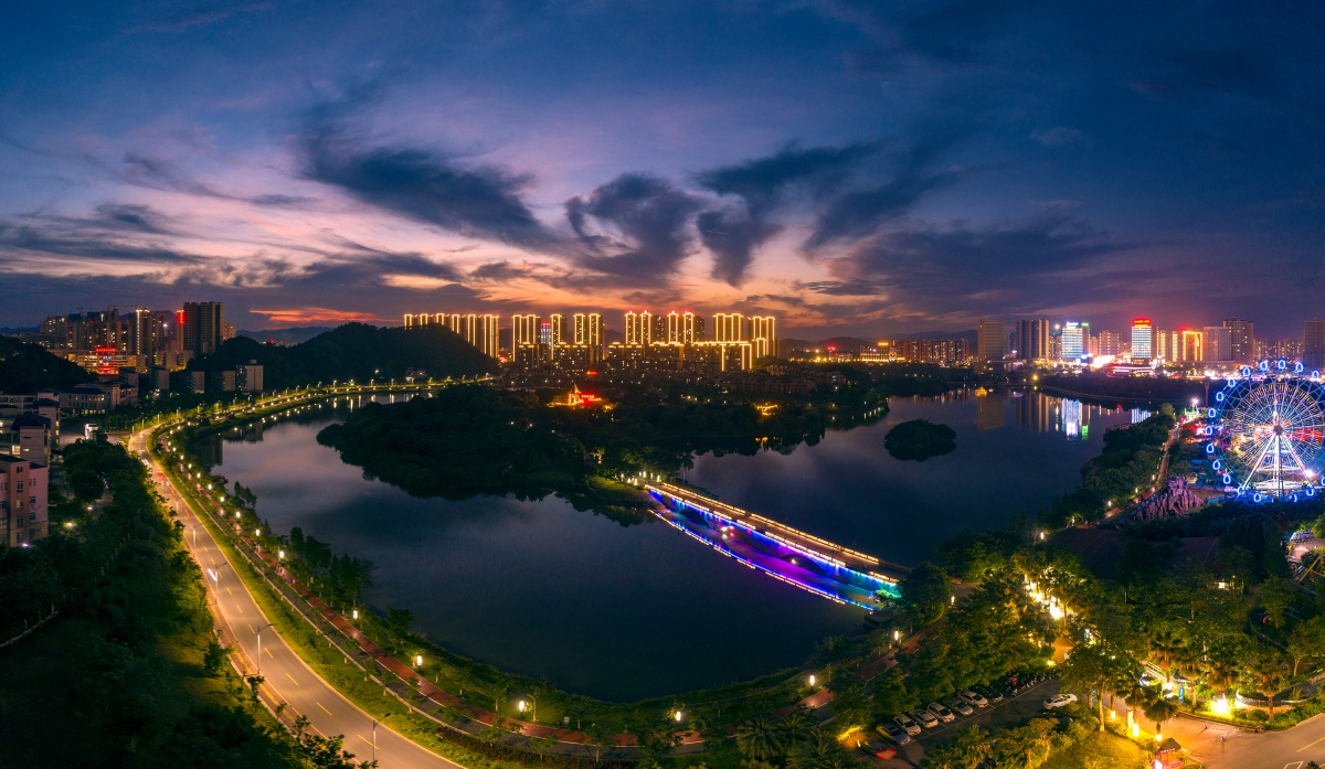 6月29日,梧州市玫瑰湖晚霞绚烂多姿,楼宇建筑与湖面交相辉映,在霞光的