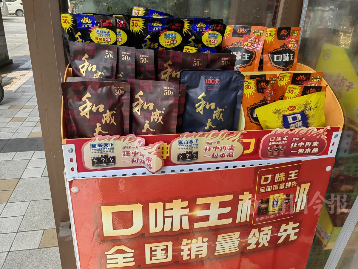 在文昌路一家烟酒店,门口的两个小货架上都有槟榔售卖.