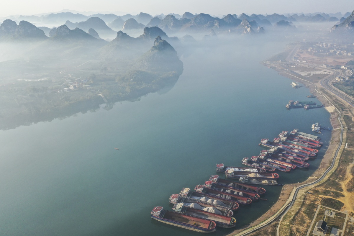 12月25日,广西来宾市武宣县黔江出现了"冬日朝阳映黔江,云雾缥缈似