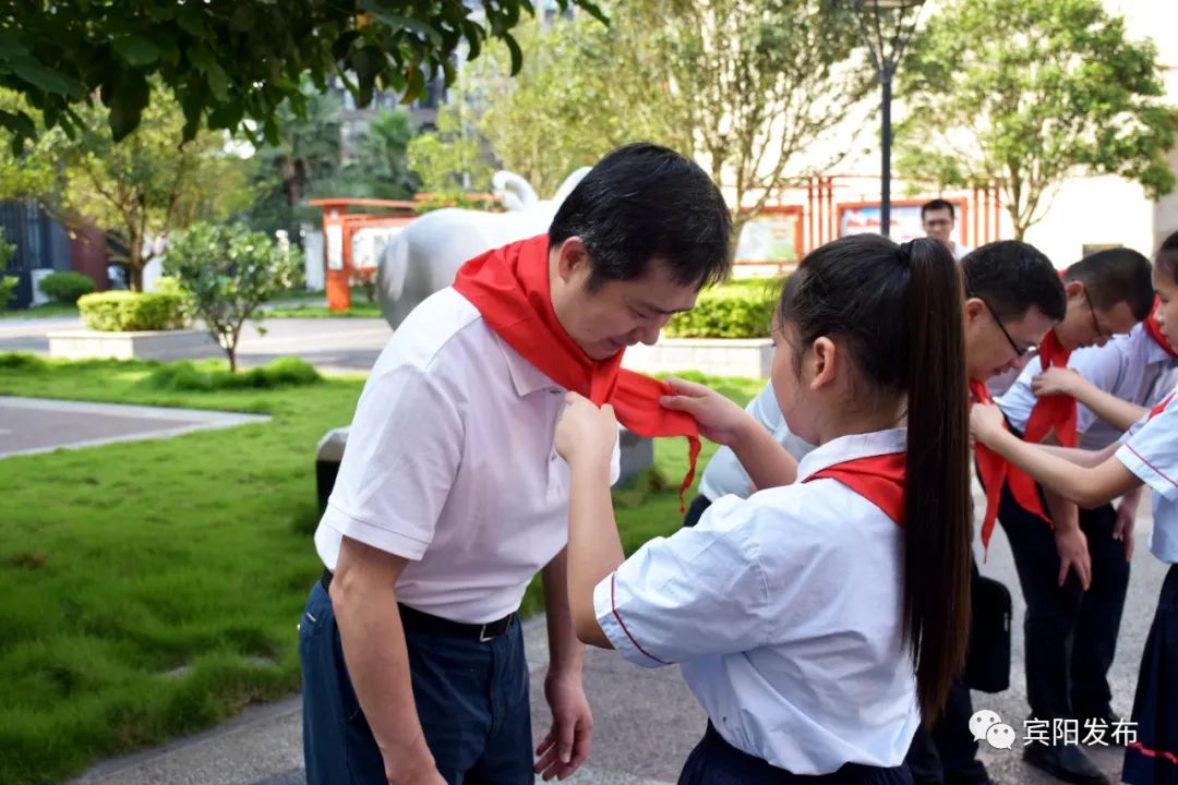 少先队员为县委书记施杰一行戴上鲜艳的红领巾,施杰亲切询问孩子们的