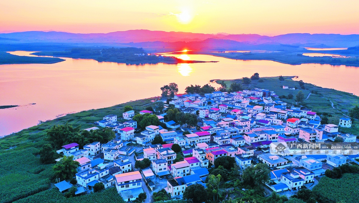 9月1日傍晚,在扶绥县东罗镇都充村,漂亮的民居与宁静的湖泊在晚霞映照