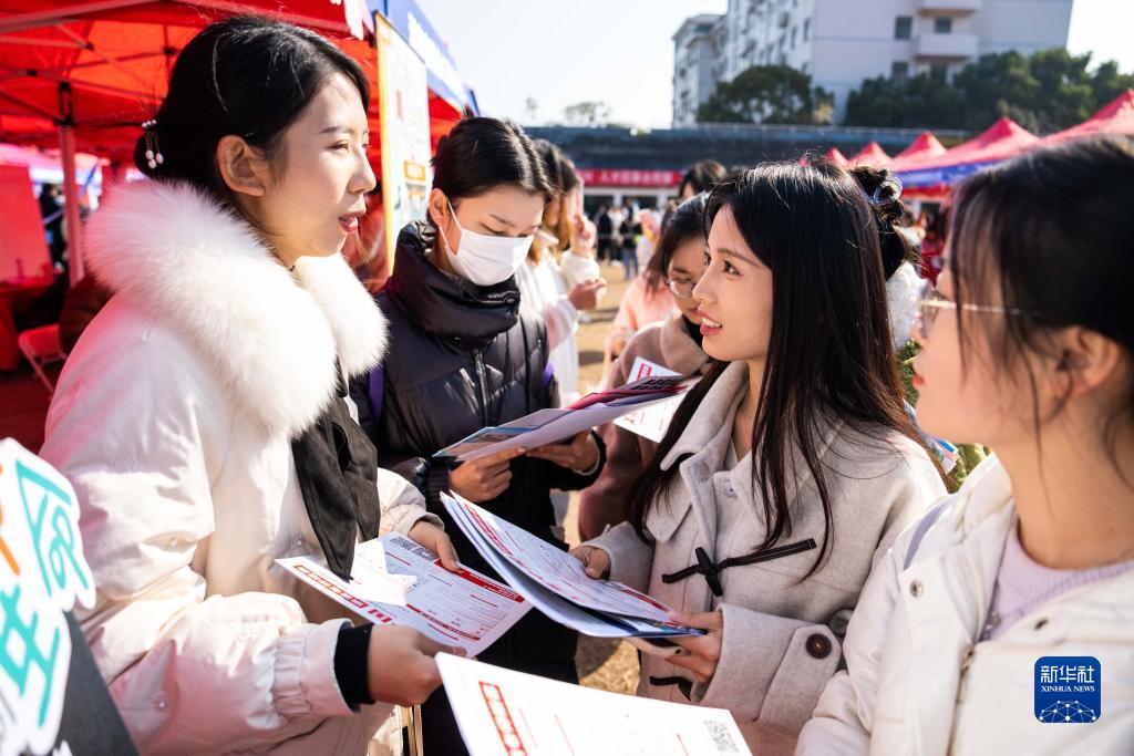 12月1日,在湖南师范大学体育场,求职学生在了解招聘信息.