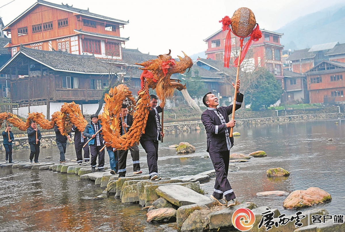 广西>正文 2月14日,当地群众和游客在灵山县丰塘镇观看舞狮等民俗活动